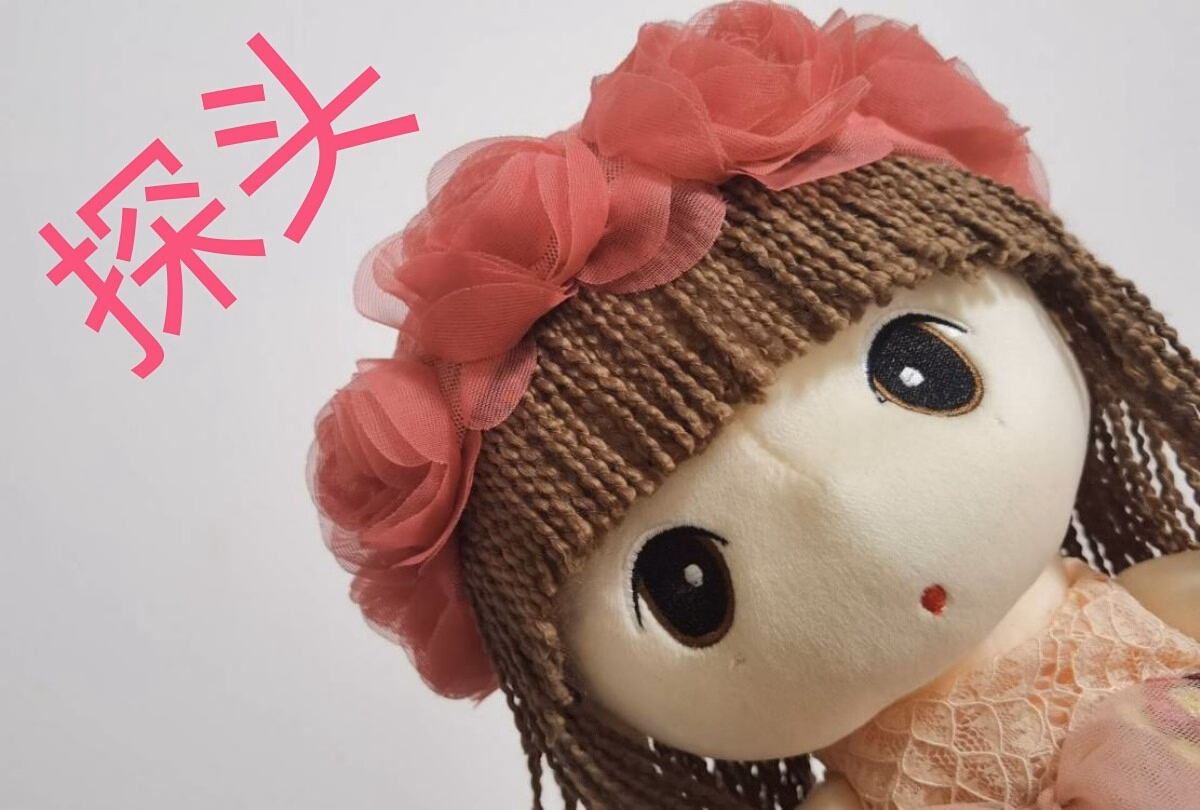 This is an image of a cute, brown-haired doll with a pink flower in her hair, wearing a brown wig, and it has pink Chinese characters in the background.  (Captioned by AI)